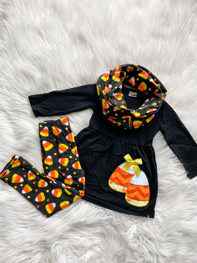 Girls three piece set with black long sleeve top embroidered with candy corn, black leggings and scarf with a candy corn pattern print. 