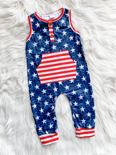 Kids Patriotic sleeveless romper with blue background with white stars and a white and red striped pocket and hems.