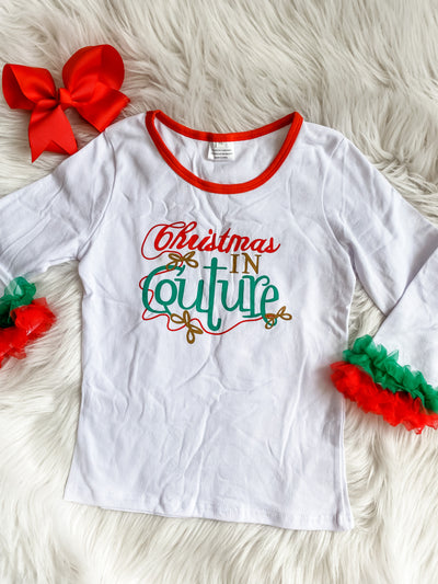 Girls long sleeve white shirt with red and green ruffles on the sleeves. Christmas in Couture saying on the front. 
