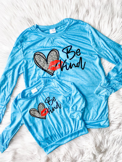 Mommy and Me Matching long sleeve blue shirts. Both shirts say Be Kind and have leopard hearts and a red kiss lips. 