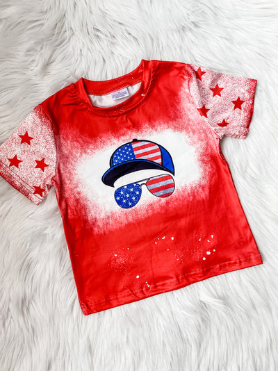 Boys red Patriotic t-shirt with American Flag hat and sunglasses printed on the front and spray paint star sleeves. 