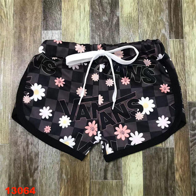 Girls black checkered dolphin shorts with white and pink daisies. 
