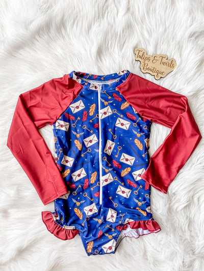 Girls long sleeve zipper swimsuit with red sleeves and wizard print. 