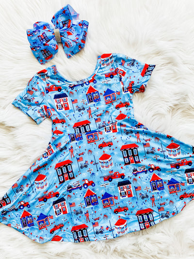 Girls light blue patriotic twirl dress with 4th of July parade graphics. 