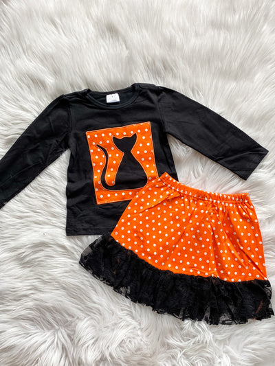 Girls two piece skirt set with a long sleeve black shirt and a black cat embroidered on a orange and white polka dot background and matching orange and white polka dot skirt with black lace trim. 
