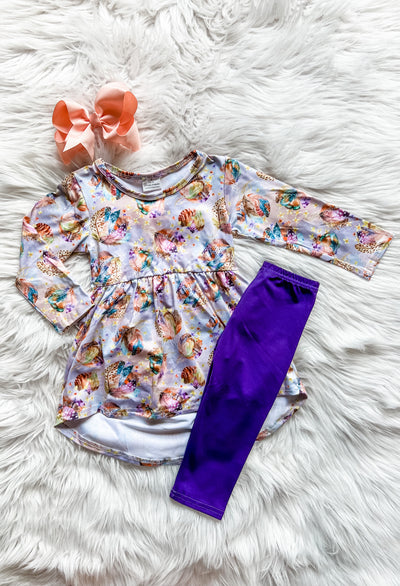 Girls two piece legging set with purple leggings and a long sleeve high low shirt with multi-colored feathers print. 