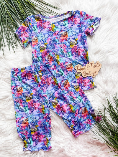 Girls two piece shorts pajama set with pink and purple colors and different aquatic sealife. 