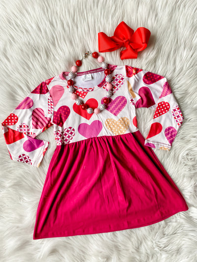 Girls valentine's day dress with different pattern hearts and a fuchsia skirt.