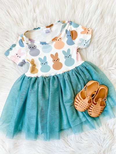 Girls Easter dress with boho print peeps and tutu skirting. Short sleeve dress with muted color peeps, teal skirting, and brown jelly sandals.