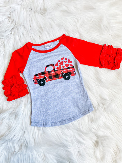 Girls raglan with red icing sleeves and a gray background with red and black plaid pickup truck with hearts in bed of truck. 