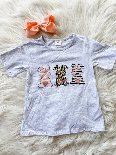 Girls grey short sleeve shirt with three different patterned bunnies on the front. 