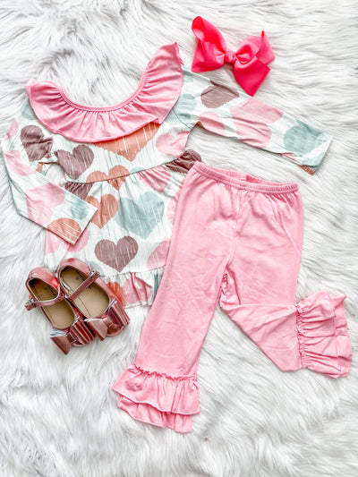 Girls two piece outfit with double ruffle pink leggings and a long sleeve top with pink collar and multi-color heart prints. 