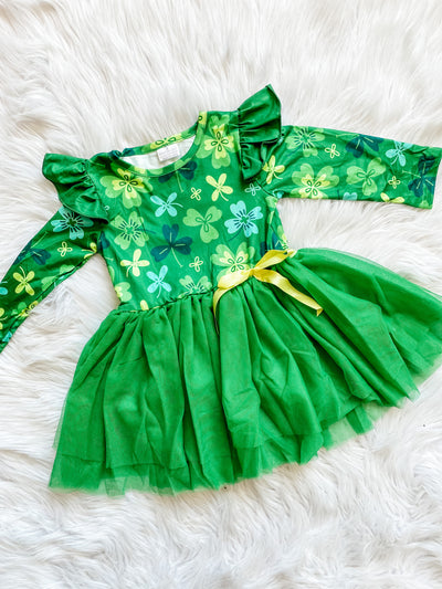 Girls dress with long flutter sleeves with shamrocks on the top, a green tutu tulle skirt and a yellow bow on the hip. 
