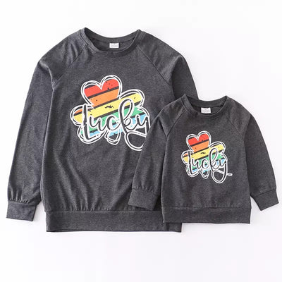 Long sleeve mommy and me matching grey shirts with rainbow clovers that say lucky. 