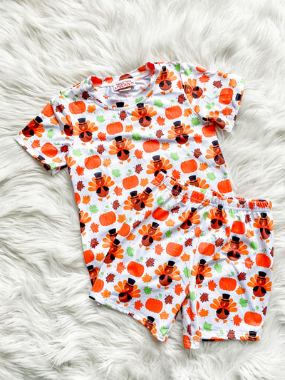 Adorable Thanksgiving pajamas for boys with shorts and shirt with all over turkey and pumpkin print. 