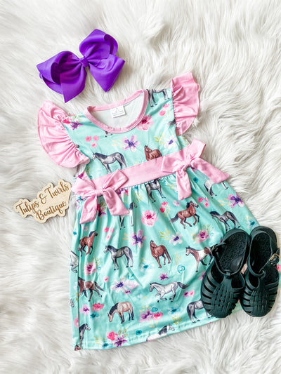 Girls flutter sleeve dress with all over horse print, pretty florals, and pink bow accents. Girls boutique dress.